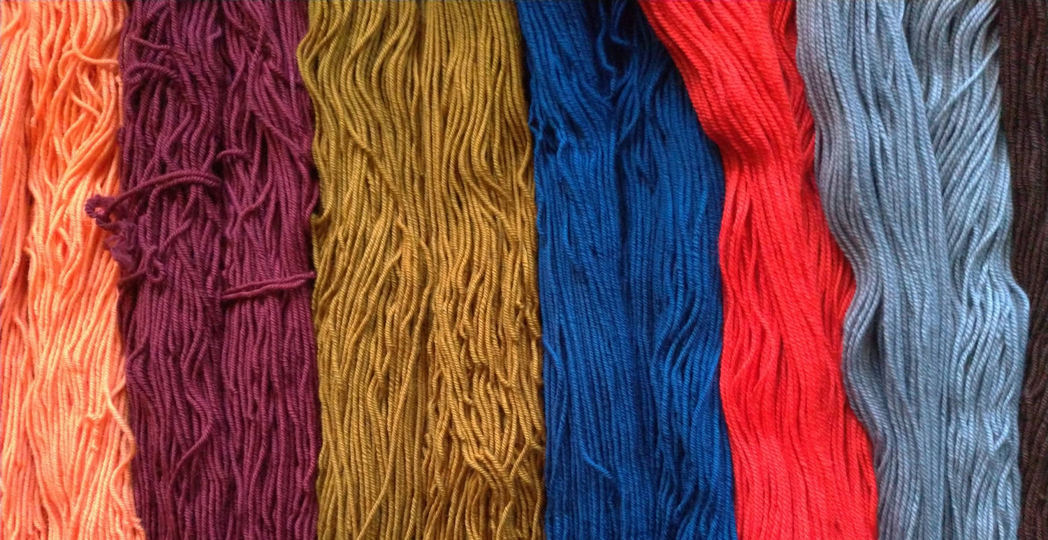 Row of colorful yarns in various shades.